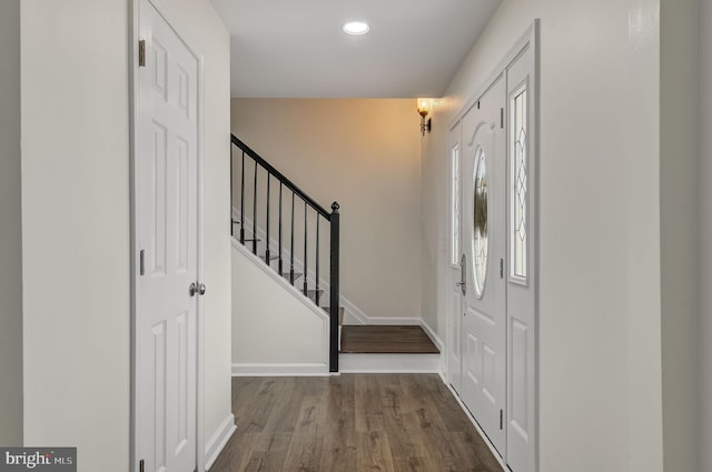 foyer featuring baseboards, stairway, wood finished floors, and recessed lighting