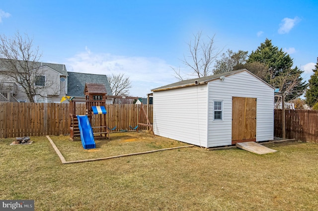 view of shed with a fenced backyard and a playground