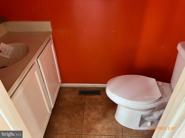 bathroom featuring toilet, tile patterned flooring, visible vents, and baseboards