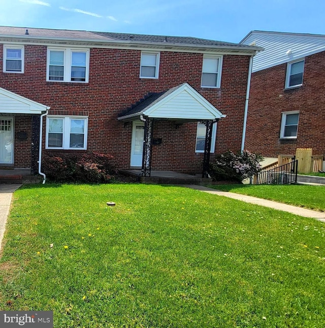 multi unit property featuring brick siding and a front lawn