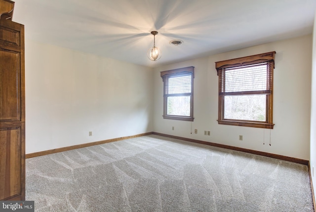 empty room with light carpet, visible vents, and baseboards