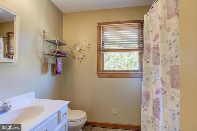 full bathroom featuring baseboards, vanity, and toilet