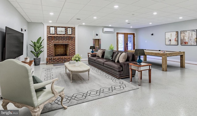 living area with recessed lighting, a paneled ceiling, a wall mounted AC, a brick fireplace, and speckled floor