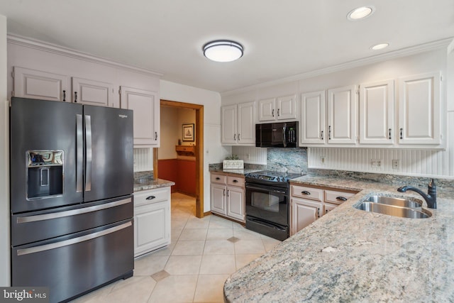 kitchen featuring light tile patterned floors, tasteful backsplash, ornamental molding, a sink, and black appliances