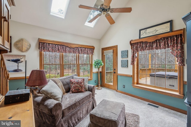 living area with a skylight, carpet, visible vents, a ceiling fan, and high vaulted ceiling