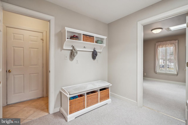 mudroom with carpet floors, tile patterned flooring, and baseboards