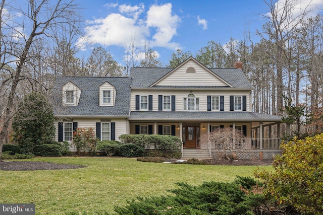 view of front of property featuring roof with shingles, a porch, and a front yard