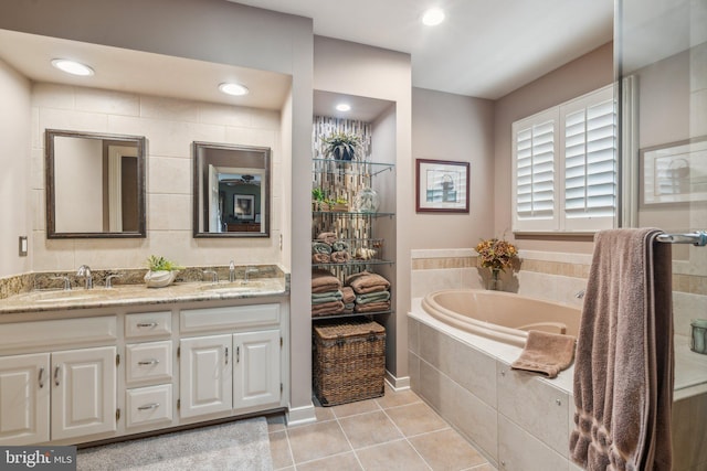 full bath with double vanity, tile patterned flooring, a sink, and a bath