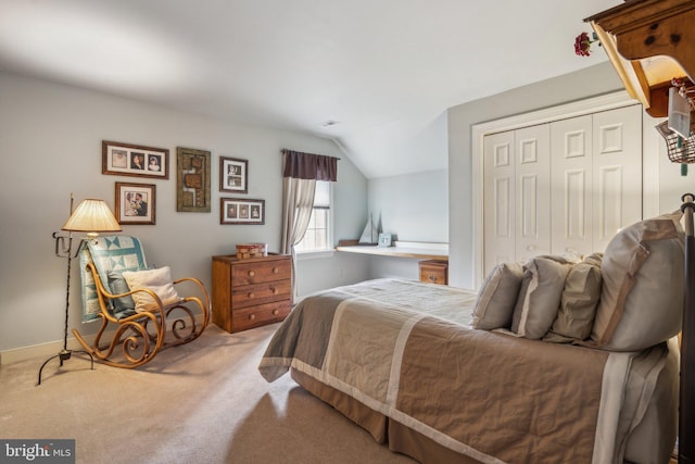 carpeted bedroom with baseboards, vaulted ceiling, and a closet