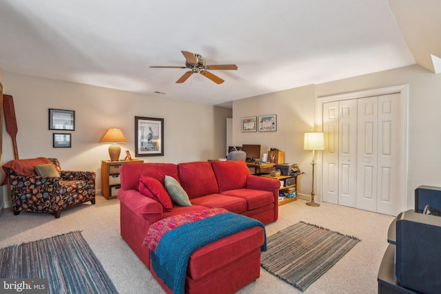 carpeted living room with ceiling fan and baseboards