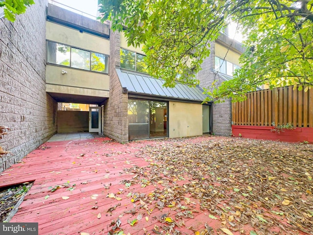 back of property featuring a standing seam roof, metal roof, a deck, and stucco siding