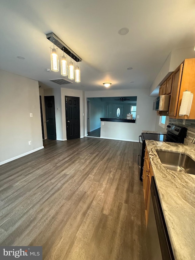 kitchen featuring open floor plan, brown cabinets, black electric range oven, dishwasher, and dark wood finished floors