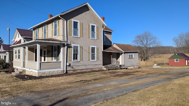 view of front of house featuring covered porch and a chimney