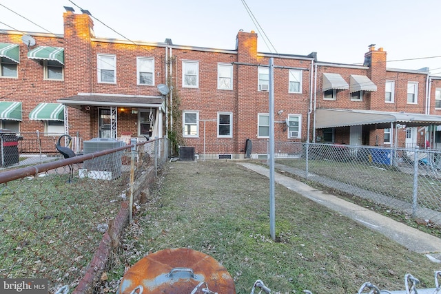 back of property with cooling unit, brick siding, and fence