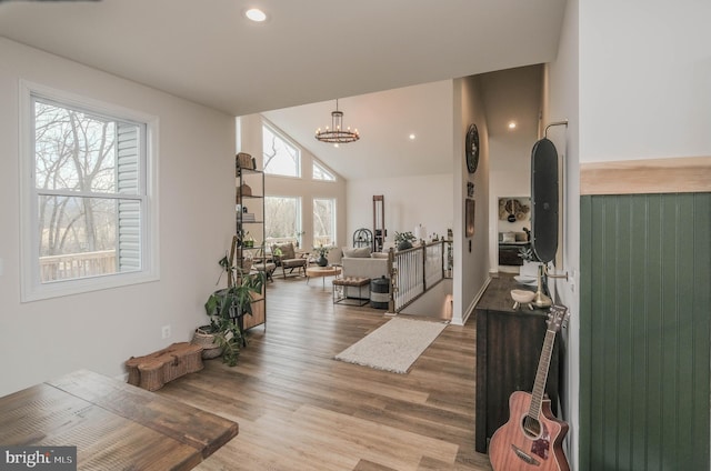 interior space with high vaulted ceiling, recessed lighting, a notable chandelier, and wood finished floors