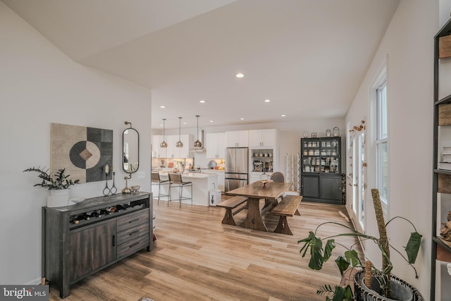 dining space with light wood finished floors and recessed lighting