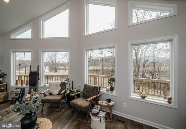 interior space featuring vaulted ceiling, visible vents, and a water view