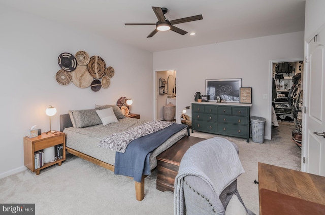 carpeted bedroom with ceiling fan, a walk in closet, and a closet