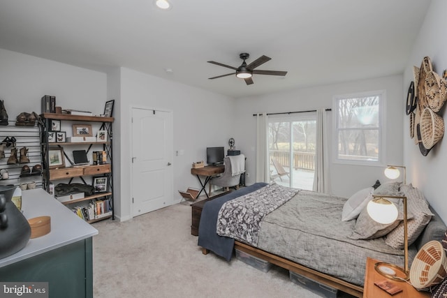 carpeted bedroom featuring access to exterior, baseboards, and a ceiling fan