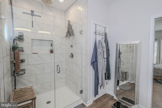 full bath featuring a stall shower and wood finished floors