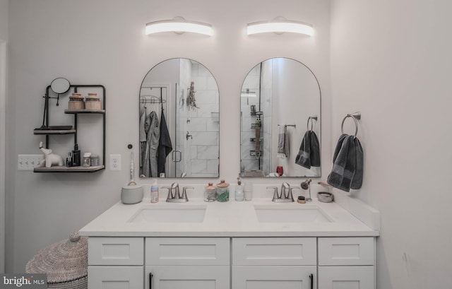 full bath with double vanity, a tile shower, and a sink