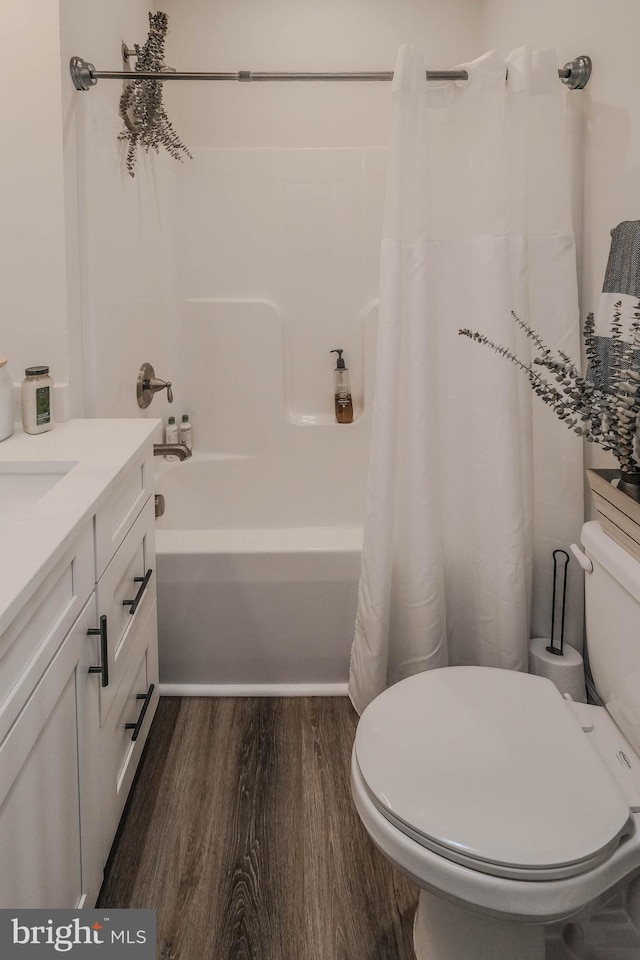 full bath featuring vanity, wood finished floors, toilet, and shower / tub combo with curtain