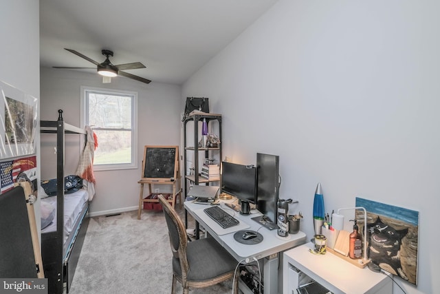 carpeted home office with a ceiling fan and baseboards