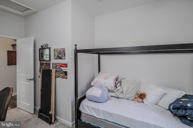 carpeted bedroom featuring attic access and baseboards