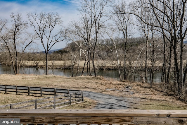 view of yard with a water view and fence