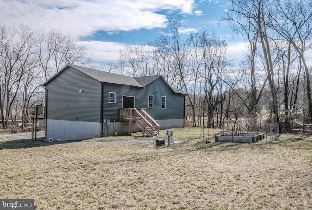 view of front of home with a front lawn, a shingled roof, and a vegetable garden