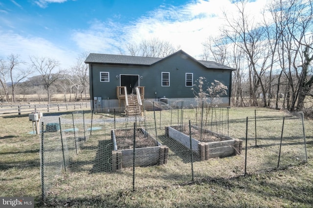 exterior space with fence and a vegetable garden