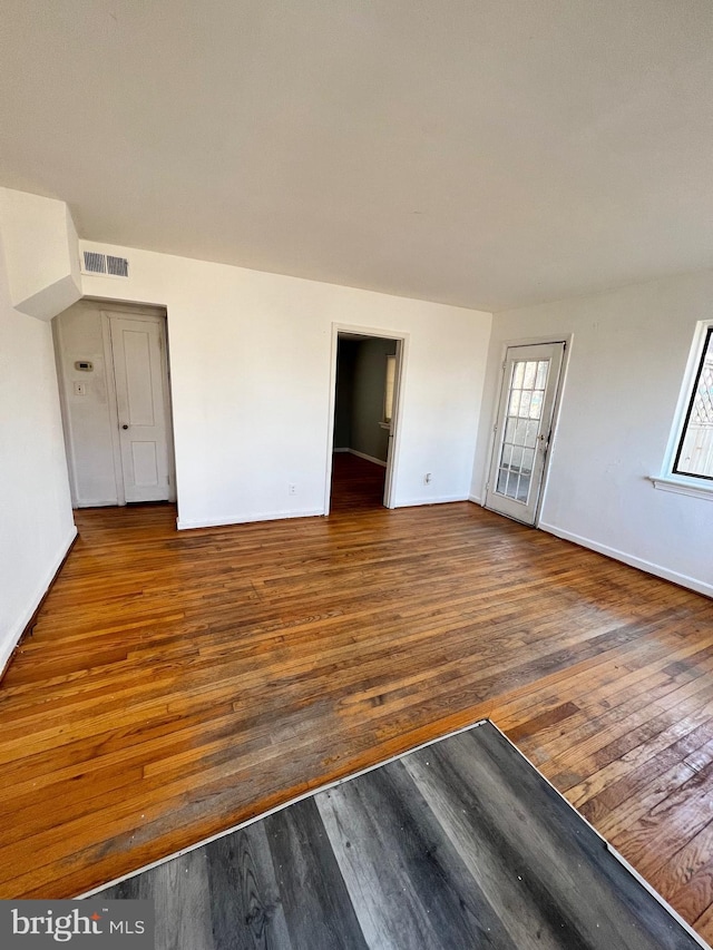 spare room featuring hardwood / wood-style flooring, baseboards, and visible vents