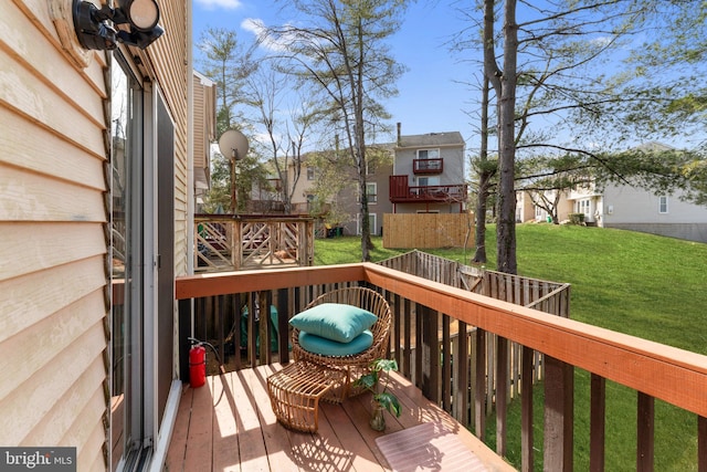 wooden deck featuring a residential view and a yard