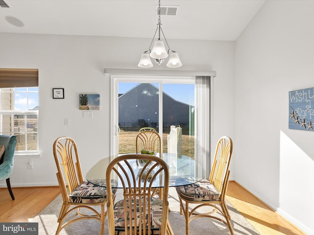 dining room featuring light wood finished floors, visible vents, and baseboards