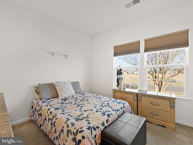 bedroom with multiple windows, visible vents, and light colored carpet