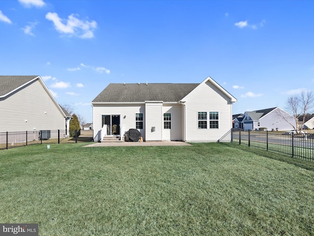 back of house with entry steps, a yard, a patio area, and a fenced backyard