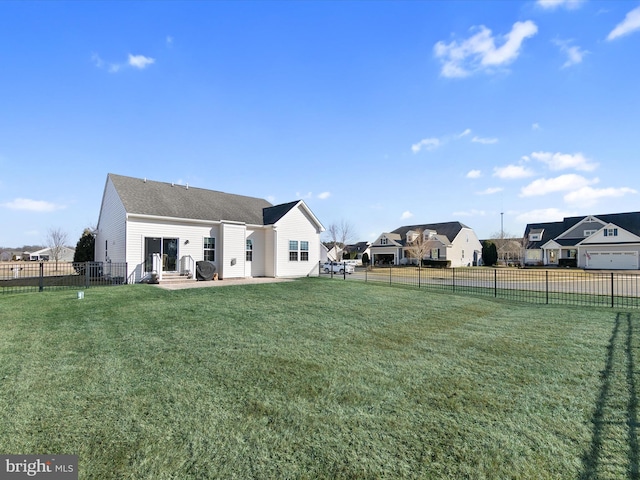 rear view of property featuring a yard, a patio area, a fenced backyard, and a residential view