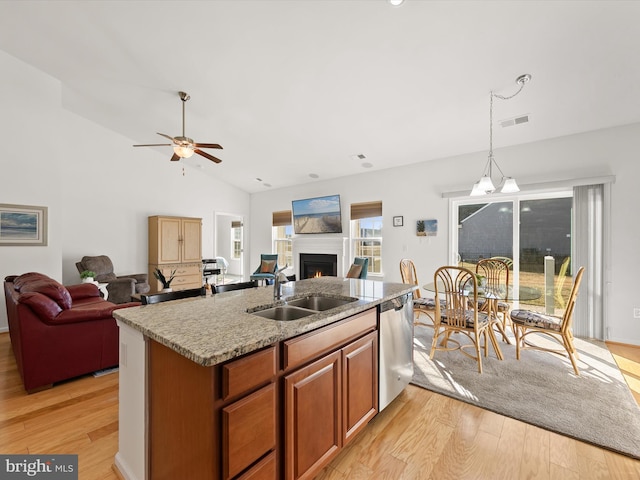 kitchen with a sink, visible vents, light wood-style floors, open floor plan, and dishwasher