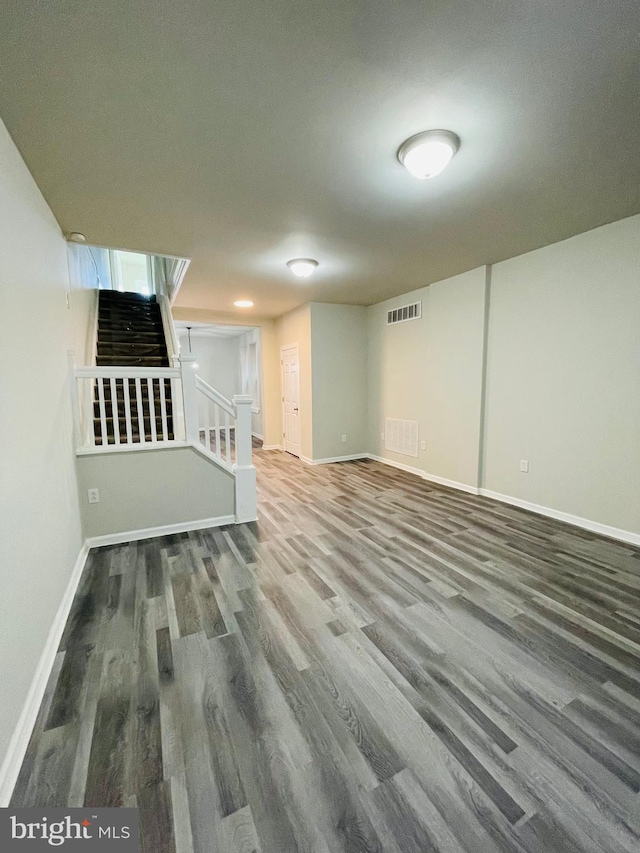 basement with stairs, wood finished floors, visible vents, and baseboards