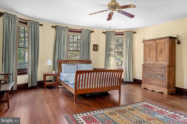 bedroom featuring dark wood finished floors, multiple windows, and baseboards