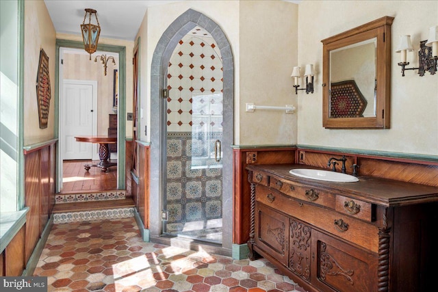 full bathroom with vanity and wainscoting