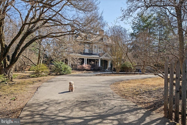 view of front of home featuring a chimney and driveway