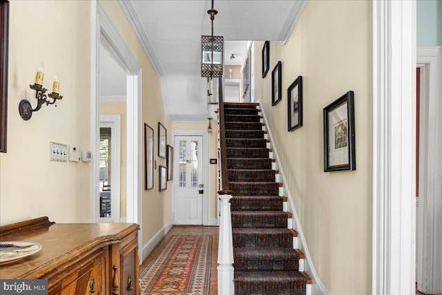 foyer with stairway, baseboards, and ornamental molding