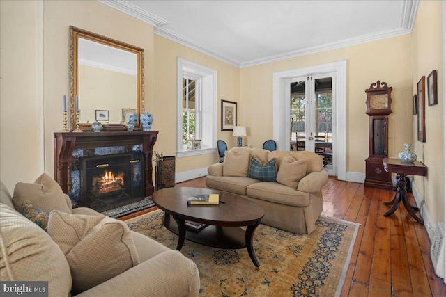 living area featuring hardwood / wood-style flooring, crown molding, french doors, and baseboards