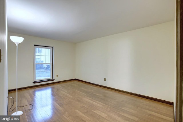 unfurnished room with light wood-style flooring and baseboards