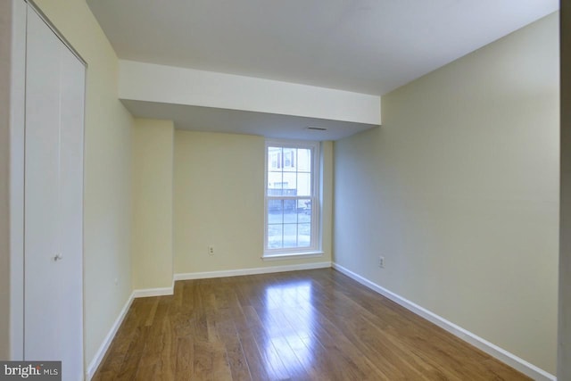 unfurnished room featuring dark wood-style floors and baseboards