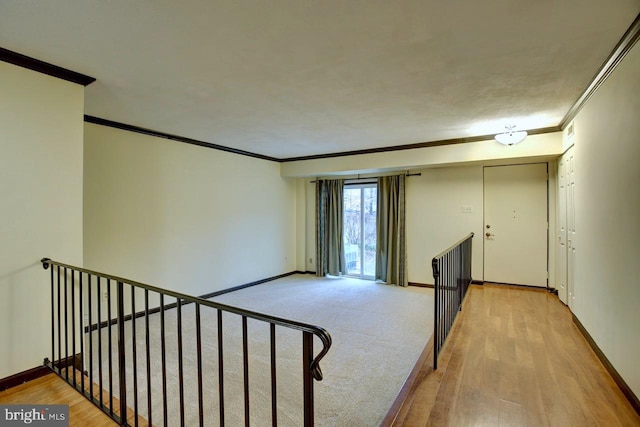 spare room featuring ornamental molding, wood finished floors, and baseboards