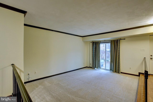 unfurnished room featuring ornamental molding, light carpet, and baseboards