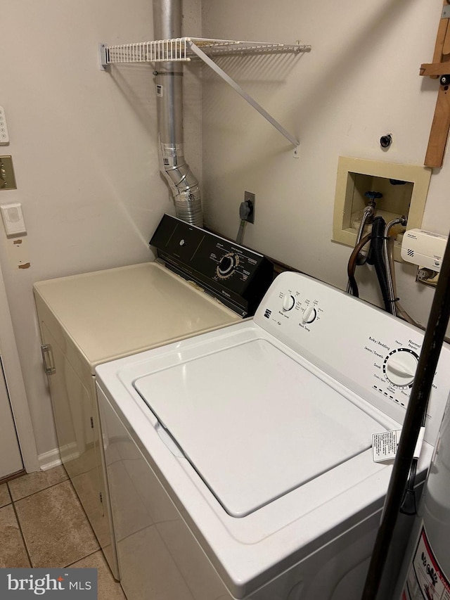 clothes washing area with laundry area, light tile patterned flooring, and separate washer and dryer