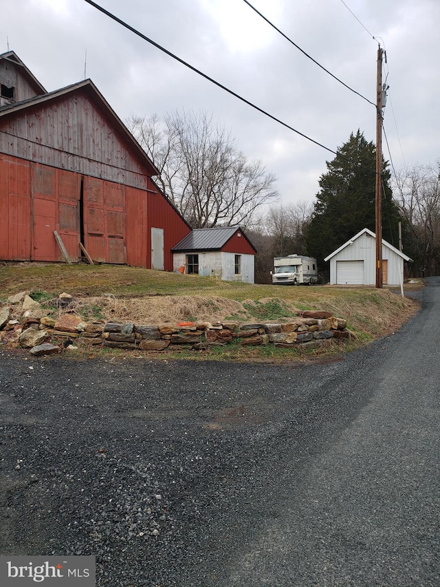 view of yard with a garage, a barn, and an outdoor structure